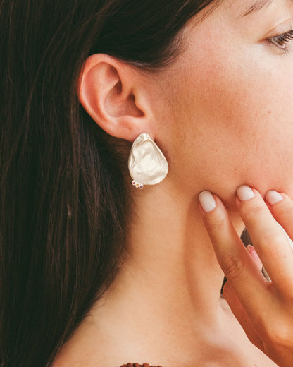 Asymmetrical shell earrings with stones.